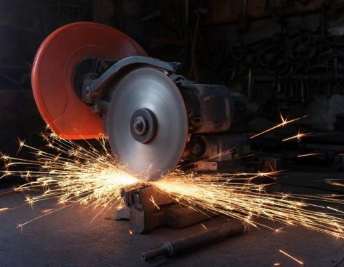 Funken sprühen von einer kreisförmigen Trennscheibe während des Schneidens von Metall.