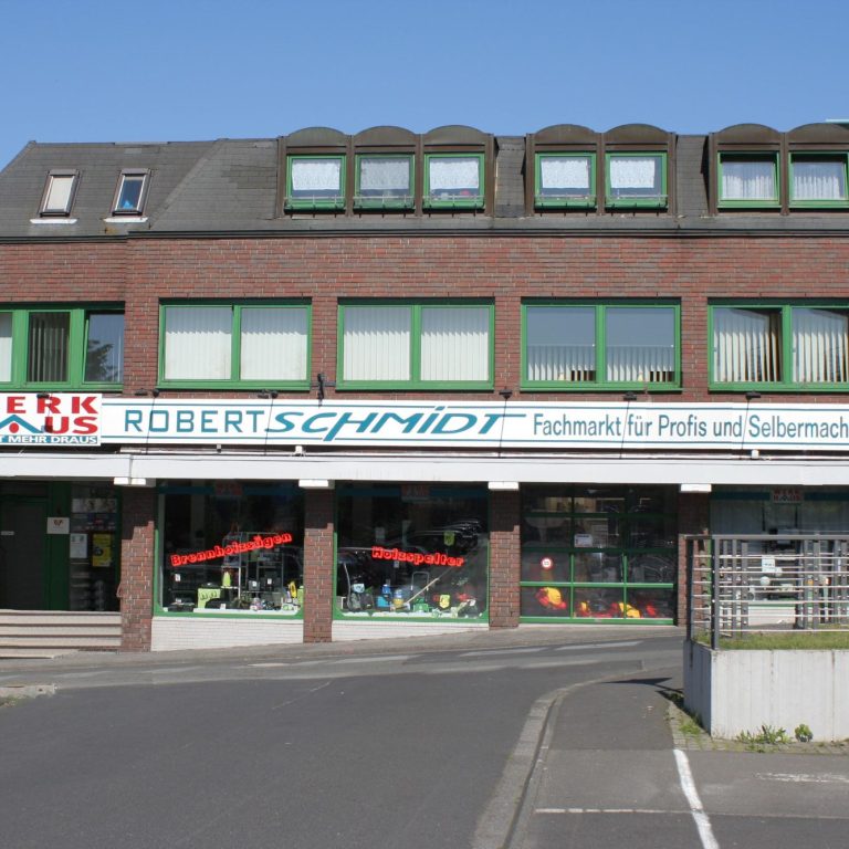 Gebäude mit Geschäftsschild "Robert Schmidt" für Produkte und Schwimmbäder.